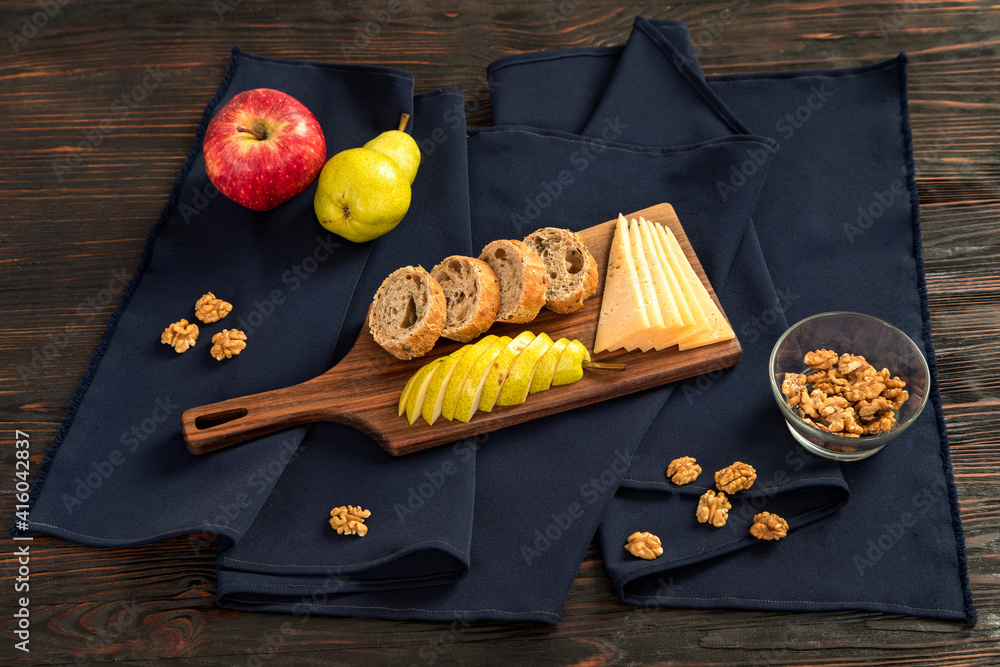 Cheese, fruits and nuts on a cutting board