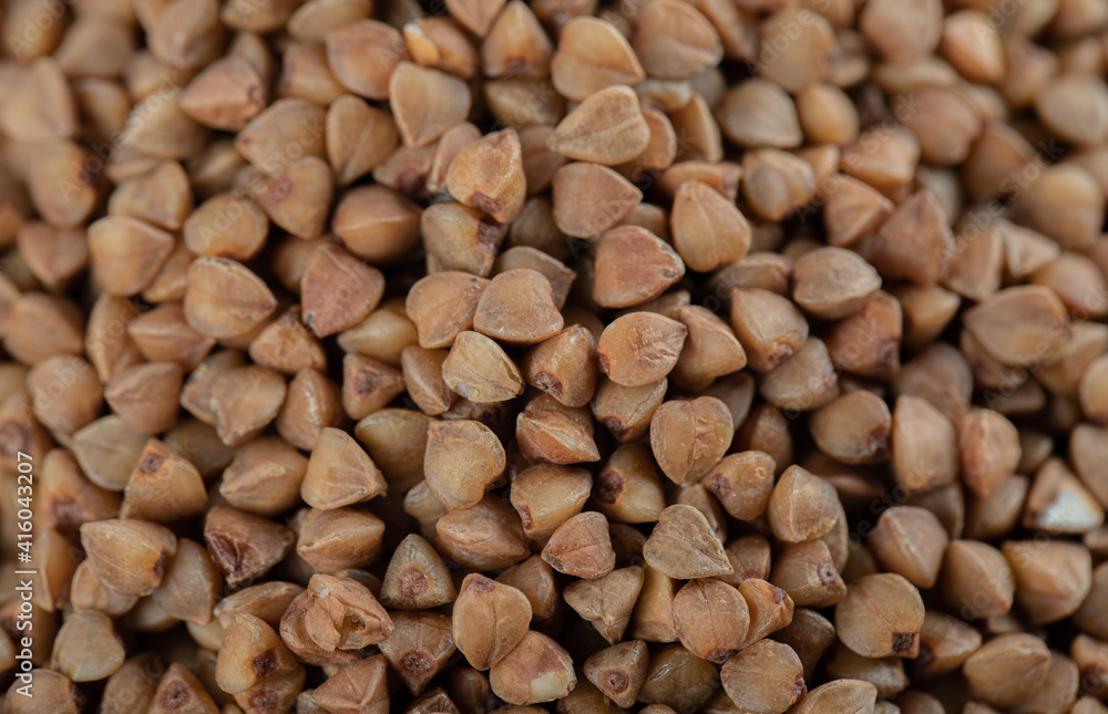 Buckwheat grain. The texture of dry buckwheat. Close-up of brown buckwheat Buckwheat grain. The texture of dry buckwheat. Close-up of brown buckwheat