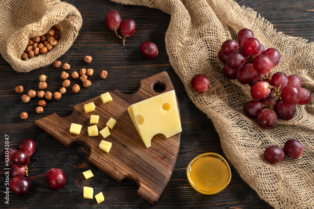 Cheese, grapes and nuts on a cutting board