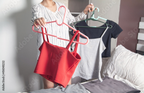 Fototapeta Naklejka Na Ścianę i Meble -  Young woman choosing clothes at home.