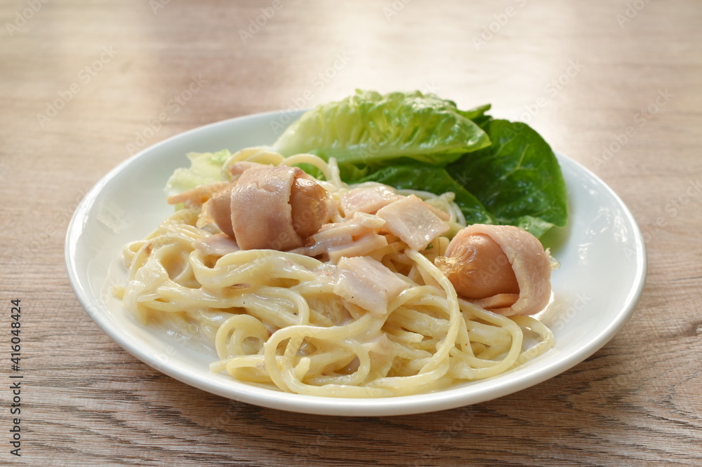 spaghetti carbonara topping slice ham pork and fresh cos lettuce vegetable on plate spaghetti carbonara topping slice ham pork and fresh cos lettuce vegetable on plate