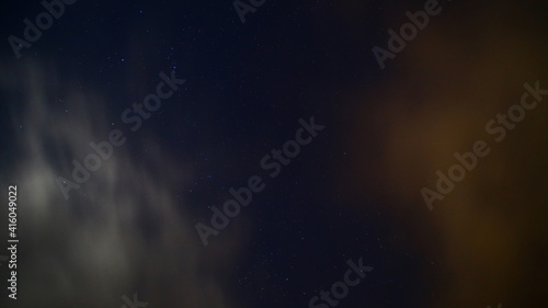 Long exposure of moving clouds on starry sky