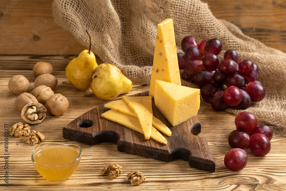 Cheese, grapes and nuts on a cutting board