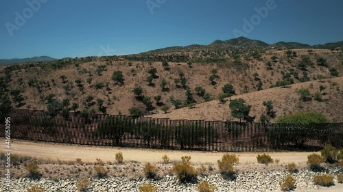 Aerial view of Nogales border area showing border fence separating the United States of America and Mexico with U.S. Border and Customs Protection patrolling border area with their vehicles