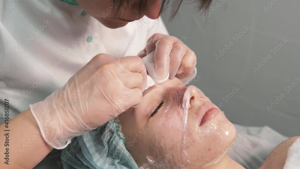The cosmetologist cleanses the face of black spots and acne. Professional skin care products. Beauty salon. The cosmetologist cleanses the face of black spots and acne. Professional skin care products. Beauty salon.