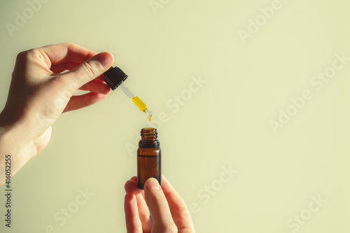 Dropper of cbd or thd oil in human hands. Essential oil, natural health products, calming supplements photo