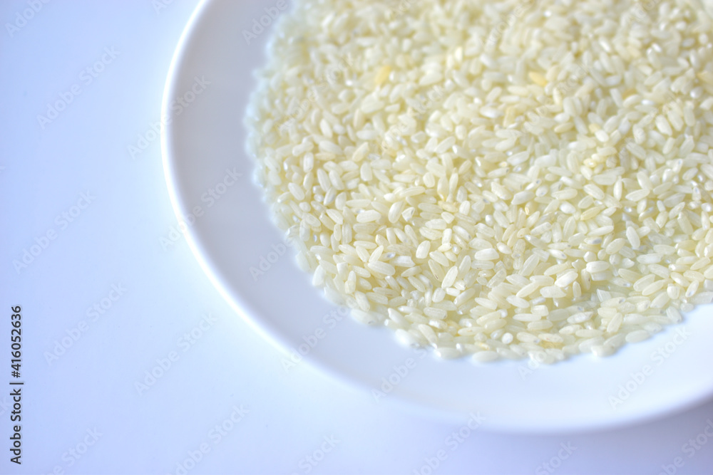 White yellow rice grains on a white plate White yellow rice grains on a white plate