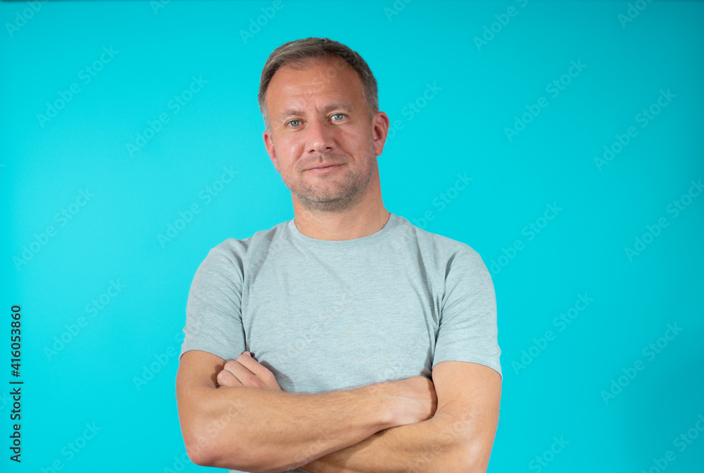 Handsome young man smiling with arms crossed over green background Handsome young man smiling with arms crossed over green background