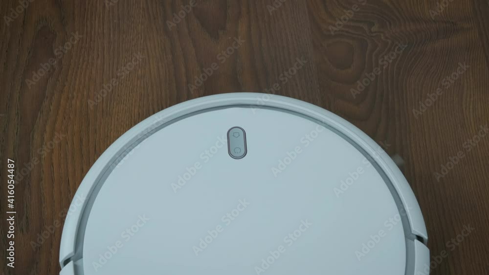 Round vacuum cleaner. Smart robot assistant washes the floor, top view.