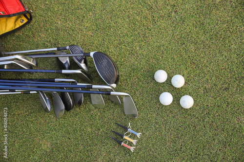 Golf balls, golf clubs and golf bags lie on the green lawn.