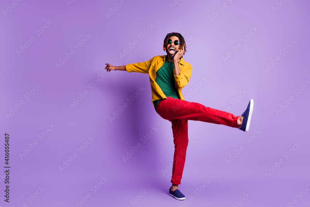 Full body photo of positive dark skin person open mouth raise leg enjoy weekend isolated on violet color background