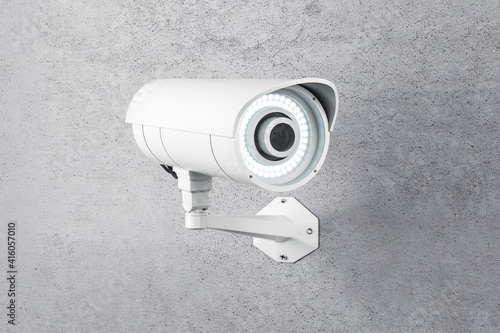 White CCTV camera installed on concrete wall outdoor