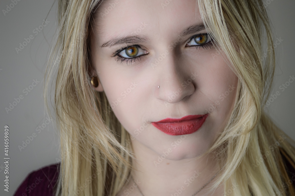 Portrait of a beautiful young blonde woman with red lipstick and intense gaze Portrait of a beautiful young blonde woman with red lipstick and intense gaze
