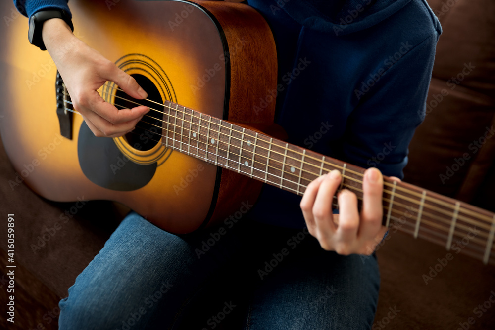 Fototapeta premium Close-up woman playing acoustic guitar. Selective focus