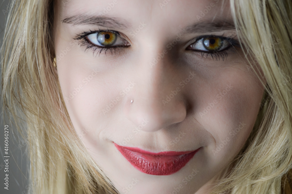 Portrait of a beautiful young blonde woman with red lipstick and intense gaze 