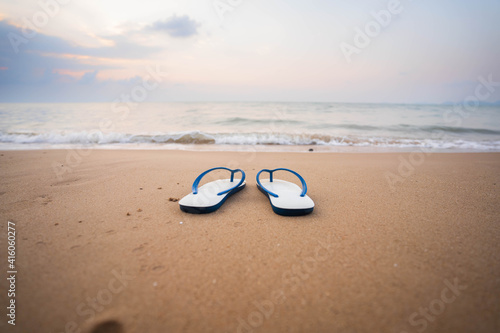 White sandals on the beach, white waves in the morning, concept.Tourism.