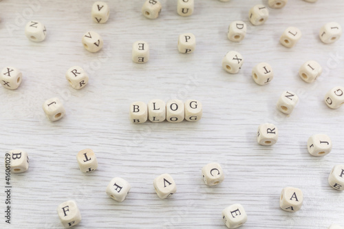 Word Blog made with block wooden letters cubes in centre surrounded by pile of other letters on wooden surface. Content marketing, blogging concept