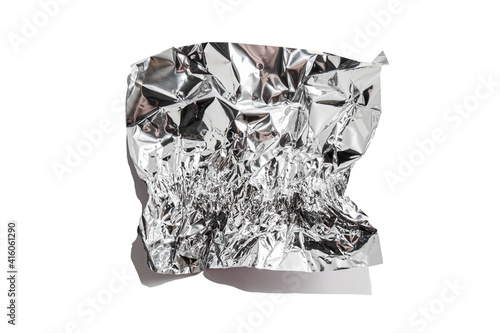 White shiny aluminum foil wrap without chocolate candy on a white background. Texture of used crumpled aluminium food foil.
