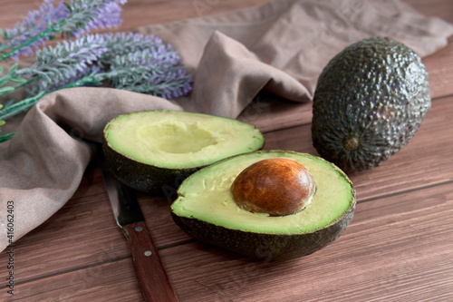 Avocado on old wooden table. Fruits healthy food concept.
