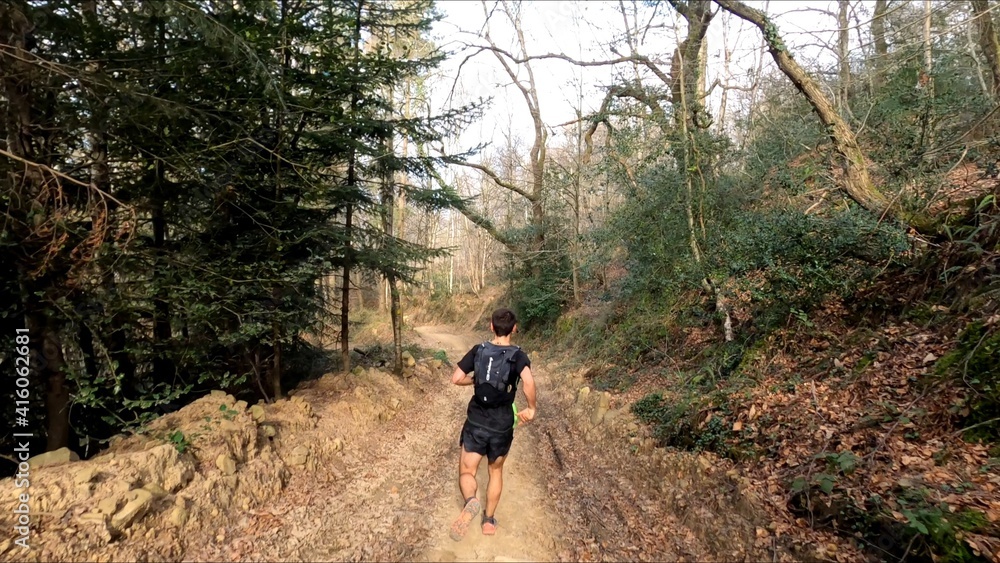 young man trail running in the mountains