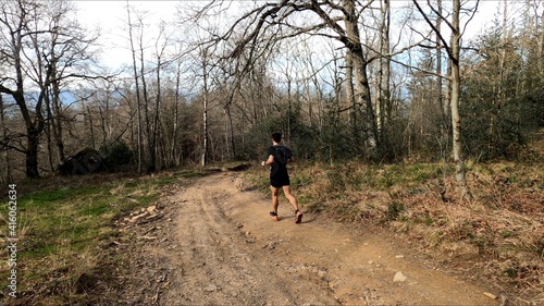 young man trail running in the mountains