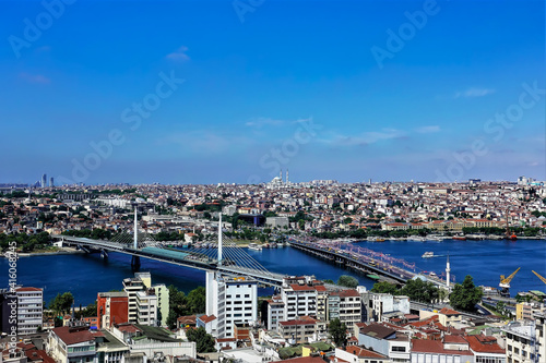 View of Istanbul from the observation deck. There are two bridges over the Bosphorus. On the opposite bank there are many modern and ancient buildings and mosques. Clear blue sky. Turkey