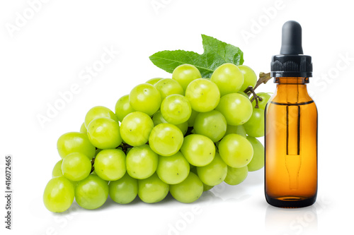 Grapeseeds oil with green grape isolated on white background. 
