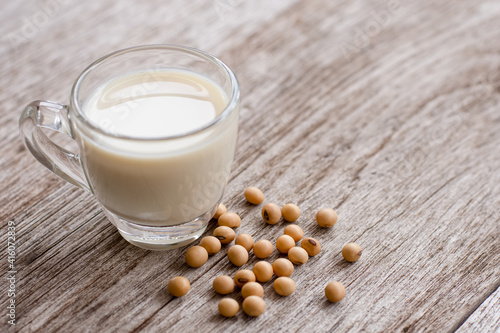 oy milk with soybeans isolated on wooden table background.