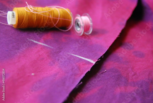 sewing fabric with threads and sewing needle