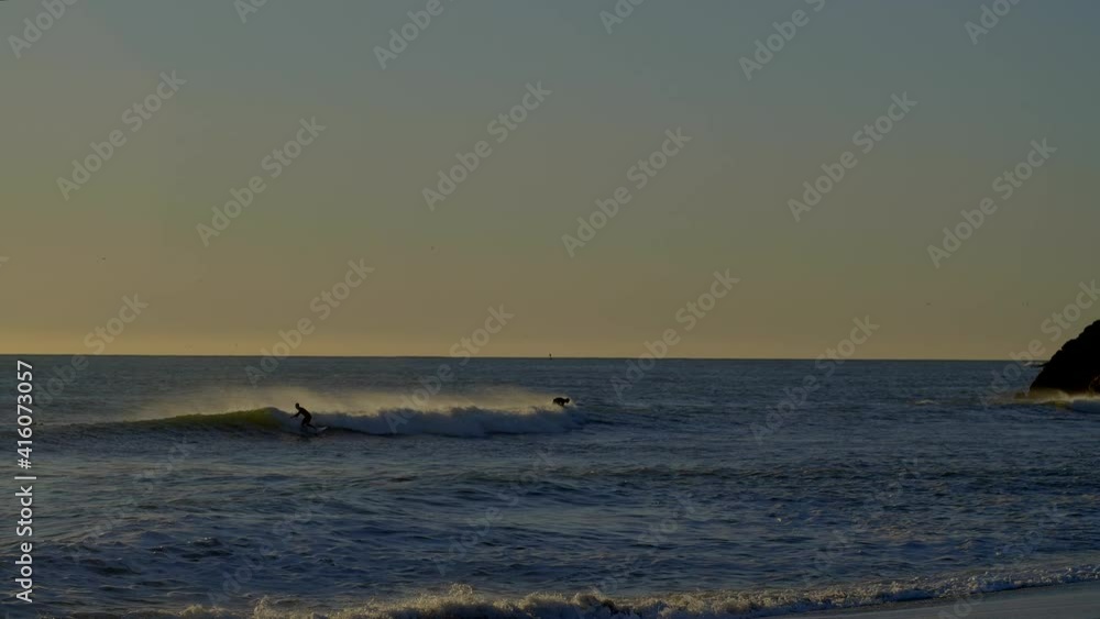 Surfers Riding Waves at Sunset in Rodeo Beach California Surfers Riding Waves at Sunset in Rodeo Beach California