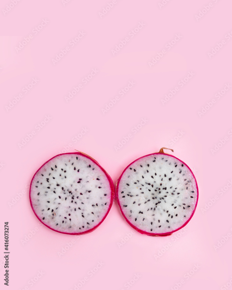 Fototapeta premium Red and pink dragon fruit slice with red and white flesh. The pitahaya fruit is low in calories, rich in essential vitamins and minerals, and contains dietary fiber.