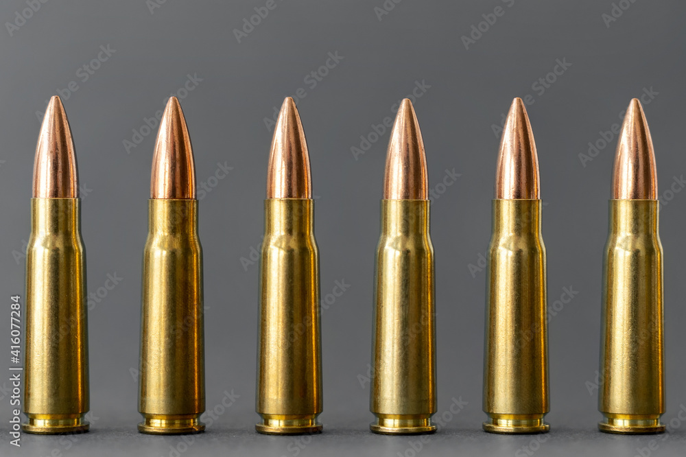 Bullets on gray background. Cartridges 7.62 caliber for Kalashnikov assault rifle closeup Bullets on gray background. Cartridges 7.62 caliber for Kalashnikov assault rifle closeup