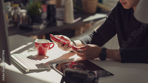 Young man hand Holding phone Office equipment placed on the table at the office