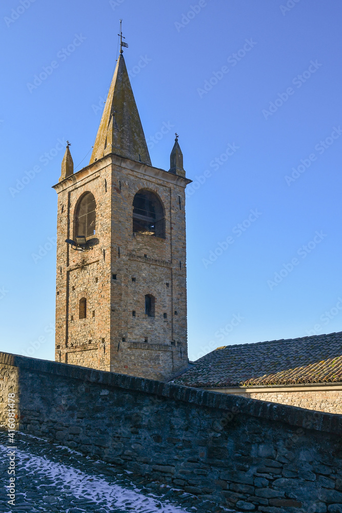 Fototapeta premium Top of a medieval bell tower in the ancient village of Serralunga d'Alba against clear blue sky, Cuneo, Piedmont, Italy