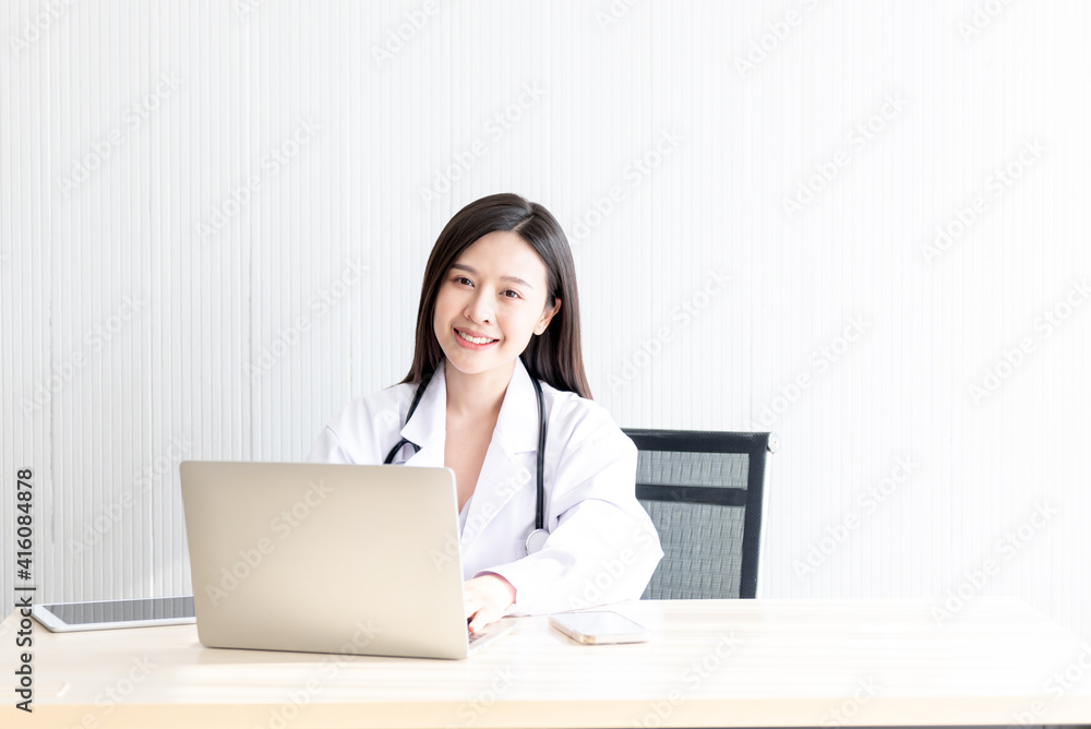 Portrait images of Asian attractive woman sitting on a table at workplace, are smile and happily On white background, to people and health concept. Portrait images of Asian attractive woman sitting on a table at workplace, are smile and happily On white background, to people and health concept.
