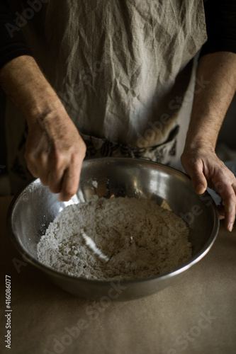 Male hands kneading batter in bowl