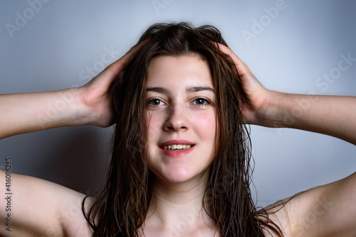 Wet hair woman portrait on gray background.