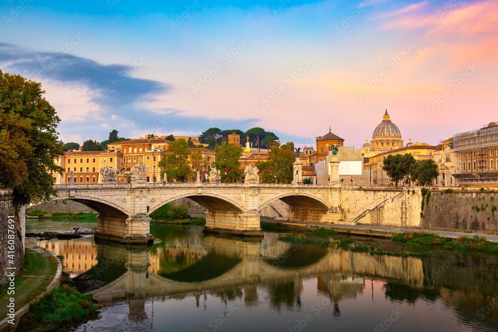 Cityscape view of Rome at colorful sunset with Ponte Sant Angelo and St Peter Cathedral in Vatican.