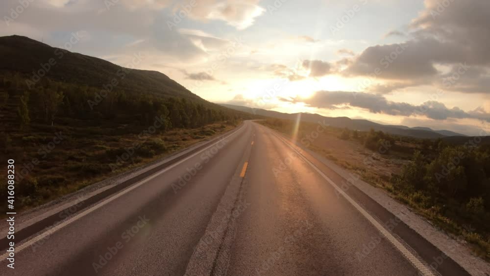 Driving a Car on a Road in Norway at dawn Driving a Car on a Road in Norway at dawn