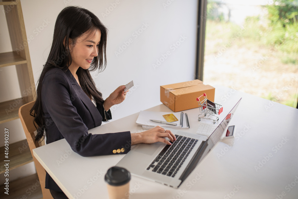 Portrait of business woman using credit card and laptop computer at home for Online shopping, e-commerce, internet banking, spending money, working from home concept Portrait of business woman using credit card and laptop computer at home for Online shopping, e-commerce, internet banking, spending money, working from home concept
