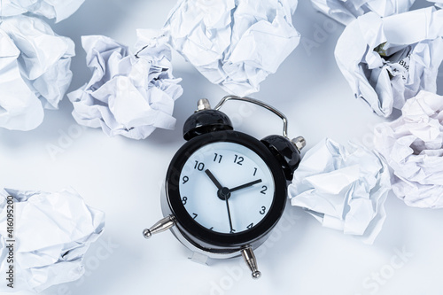 Alarm clock with crumpled paper balls.Timing and thinking idea concept.