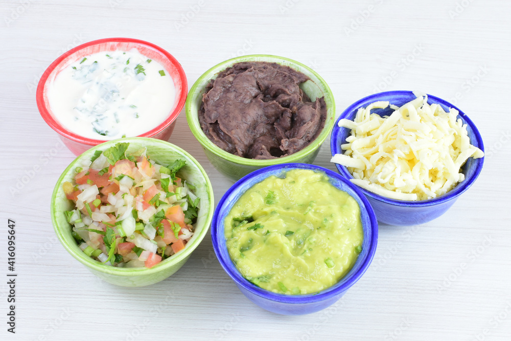 Sauces and dressings for Mexican food in bowls on white wooden background