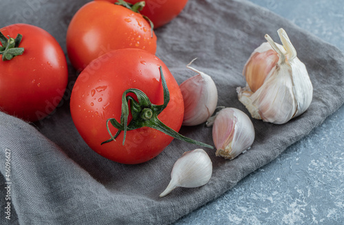 Fresh tomatoes with garlic on a gray tablecloth