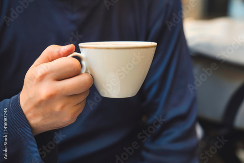 カフェで男性がコーヒーを飲むシーン