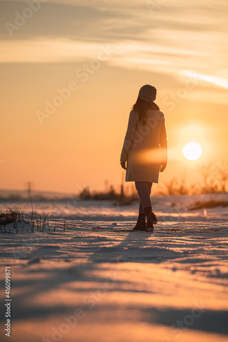 Woman enjoying sunset in snowy field