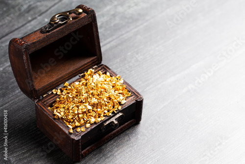 Pieces of Gold in a Treasure Chest on Wooden Table