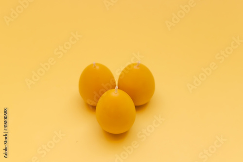 Yellow candle from beeswax in the form of egg for celebrating Easter.