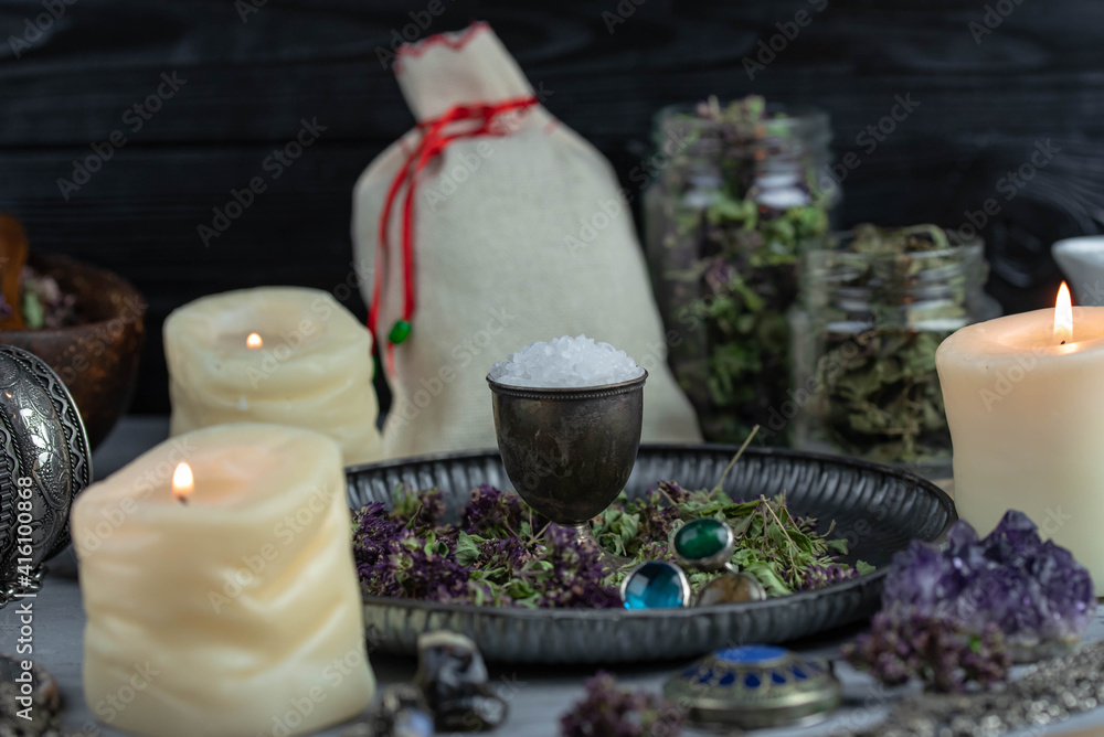 Magic altar with mystical herbs, salt, candles and crystals. Witch sanctuary sacred esoteric concept.