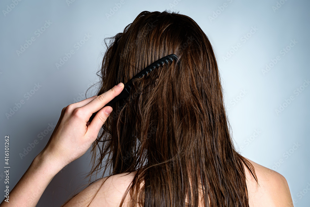 A young woman combing your wet hair after washing hair. Stock Photo | Adobe  Stock