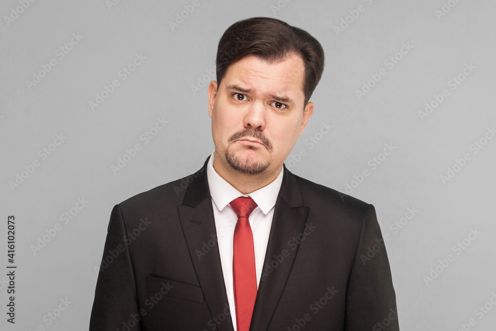 Sad, looser businessman, crying, looking at camera and hope. Need a new job and money. isolated on gray background. handsome businessman with black suit, and mustache looking at camera.